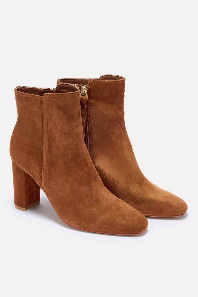 Pair of brown suede ankle boots on a white background