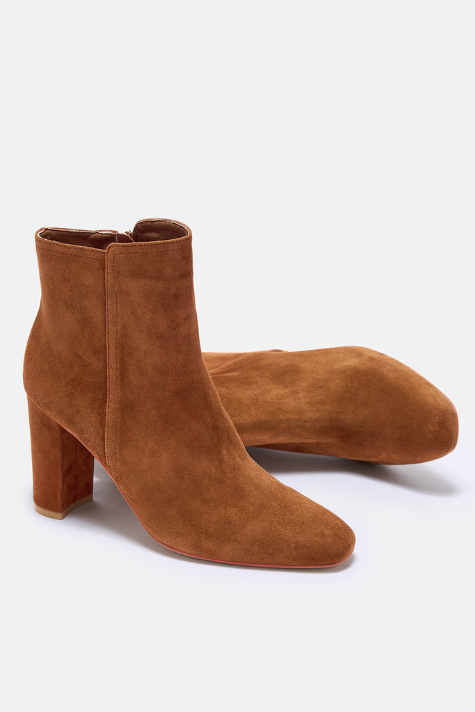 Brown suede ankle boots on a white background