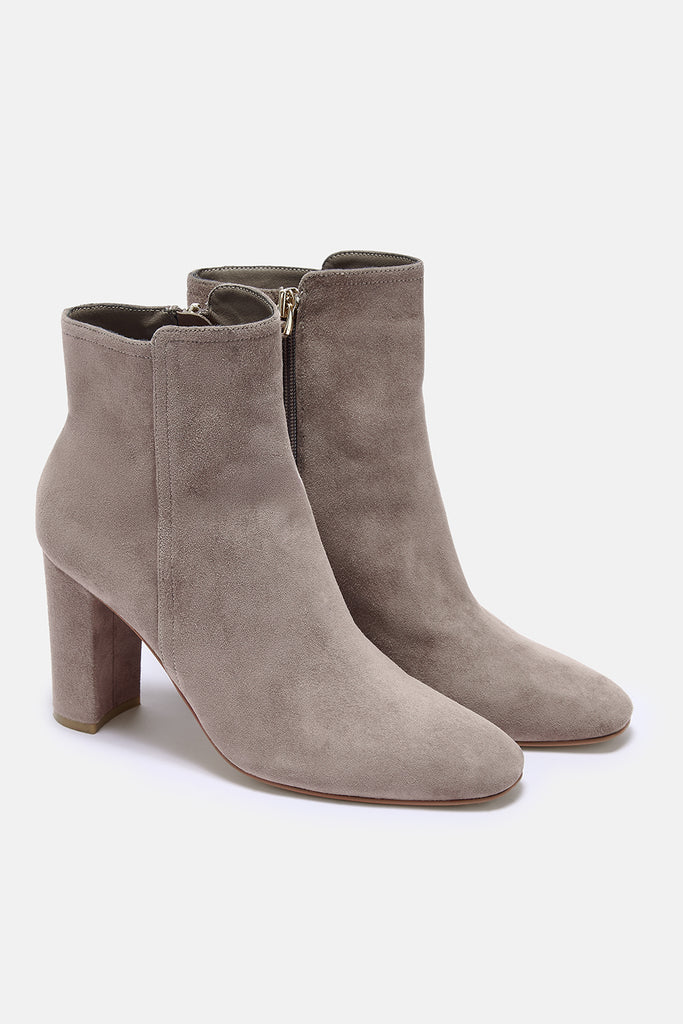 Pair of taupe suede ankle boots on a white background