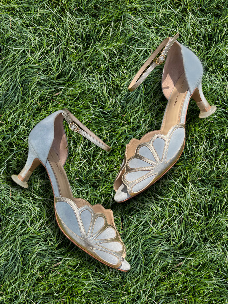 Pair of high-heeled shoes with floral design on grass