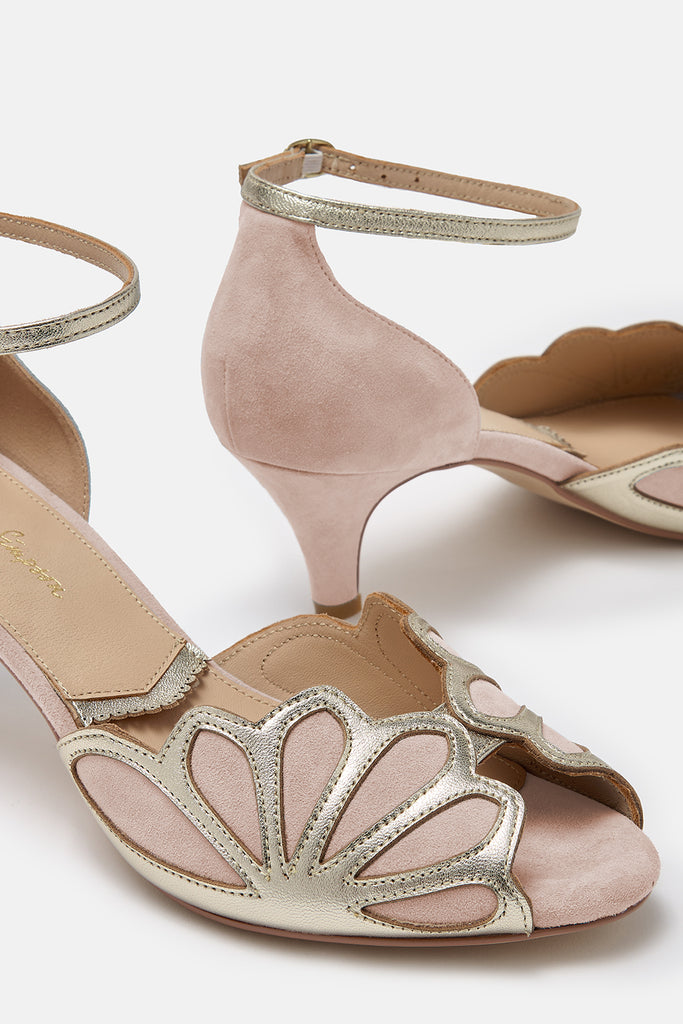 close up detail shot of a pair of pair of blush pink suede and gold art deco vintage style shoes, with low heels and ankle strap