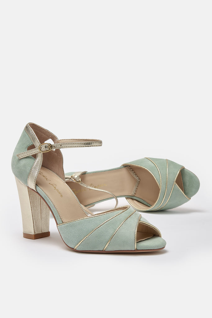pair of mint green suede occasion shoes with gold block heel and ankle strap- one of the shoes is lying on its side