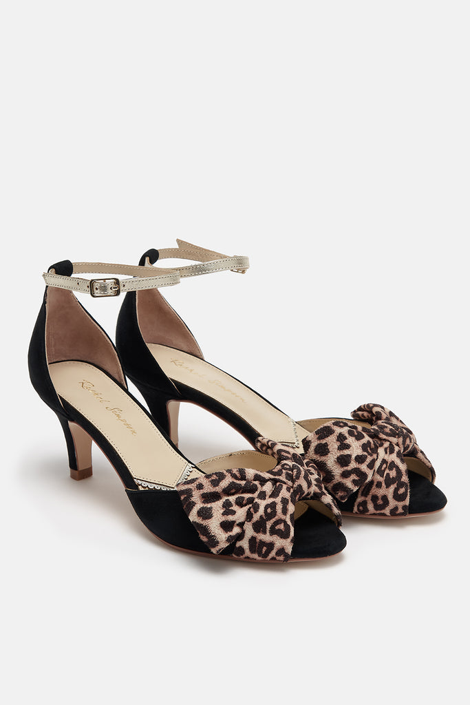 pair of black suede low heel two part occasion shoes, with oversized leopard bows and gold leather ankle straps
