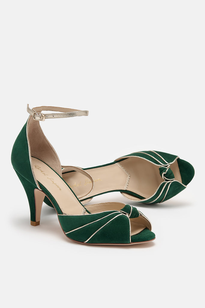 pair of forest green and gold two part occasion shoes, with vintage inspired knot detail, mid heels and gold leather ankle straps- one shoe is lying on its side