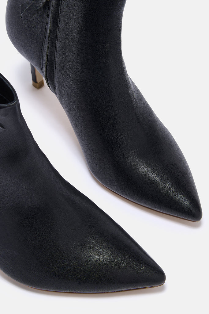 Black pointed-toe high-heeled boots on a white background