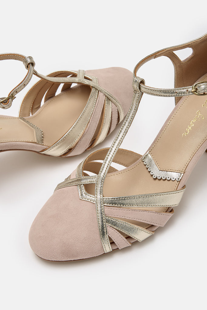 close up detail shot of a pair of blush pink suede and gold leather twenties vintage style t-bar occasion shoes, with low heels and ankle straps