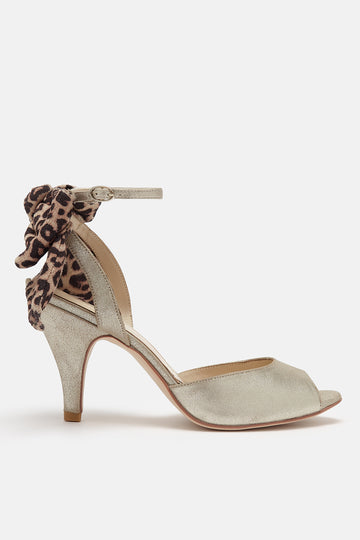 antique gold leather ankle strap sandal with oversized leopard bow on the back and mid heel- side view